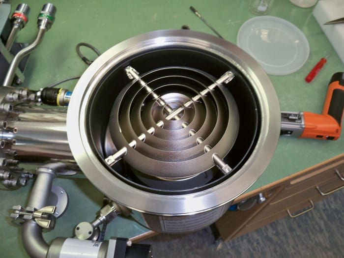 Innenansicht eines Kryostaten, die ein Element mit konzentrischen, gewellten Metallrippen zeigt.