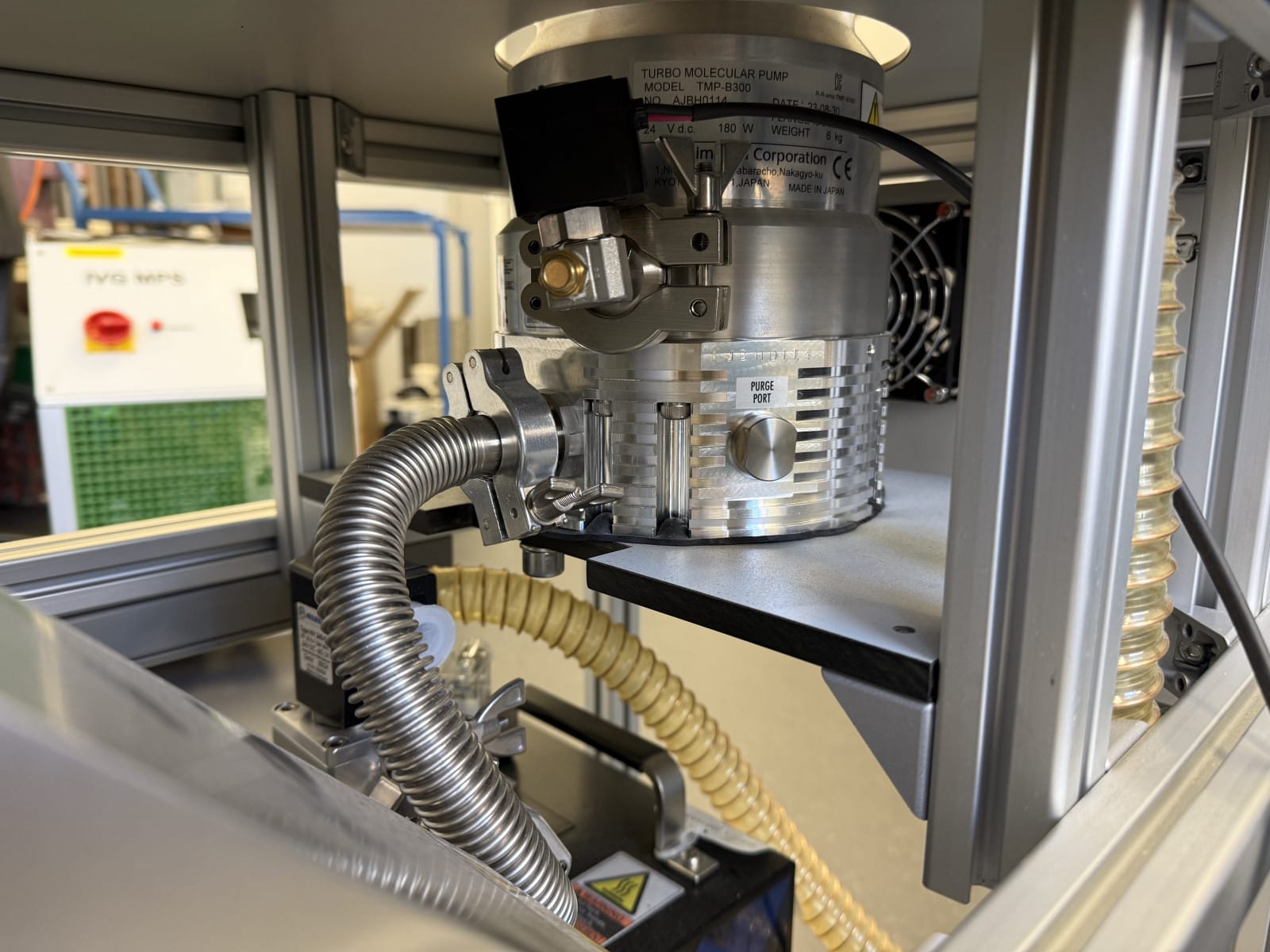 Close-up of a silver turbomolecular pump (model TMP-B300) in an aluminum frame.